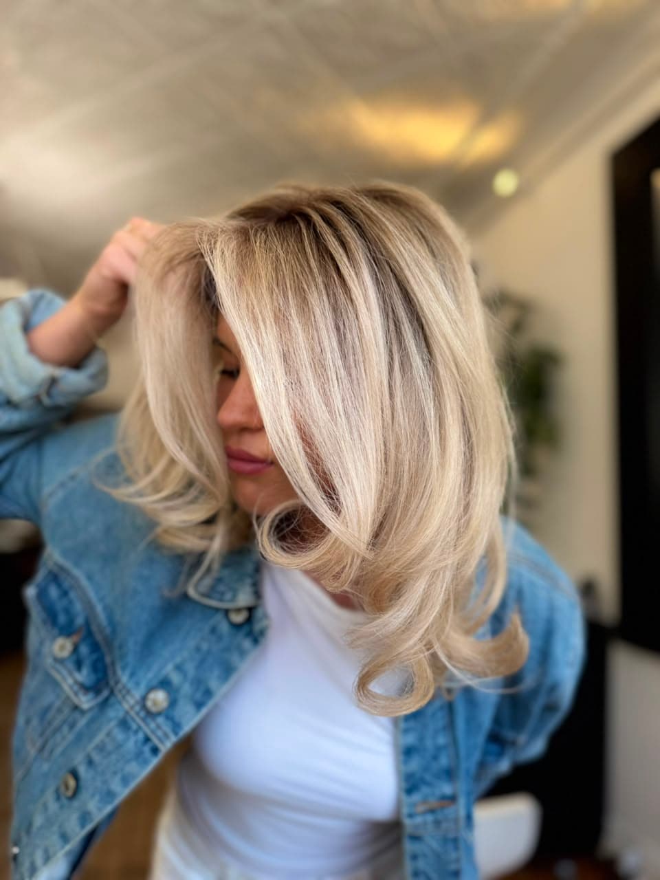 Shoulder-length creamy blonde with flicked ends and a soft root