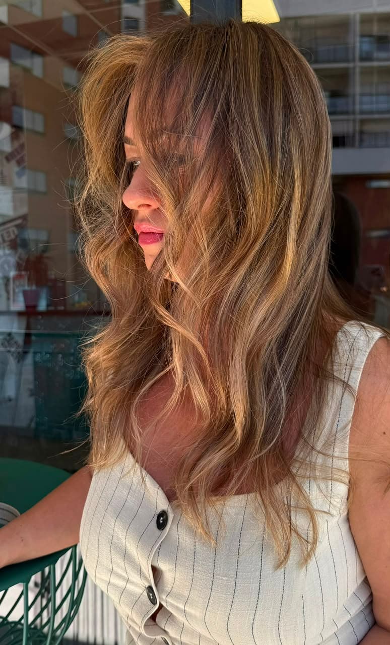 Side view of tousled honey and caramel bronde waves